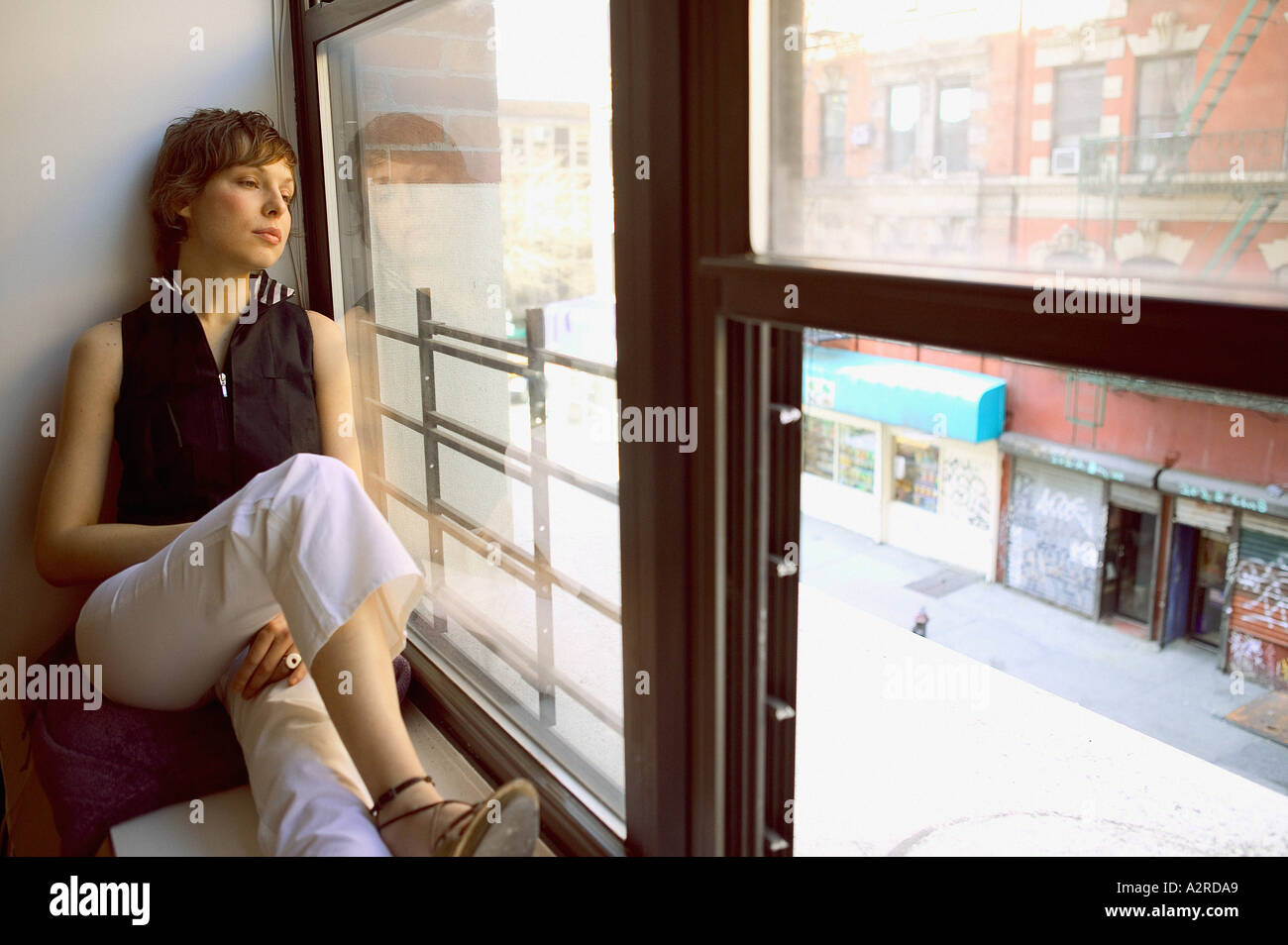 Woman sitting on ledge window hi-res stock photography and images - Alamy