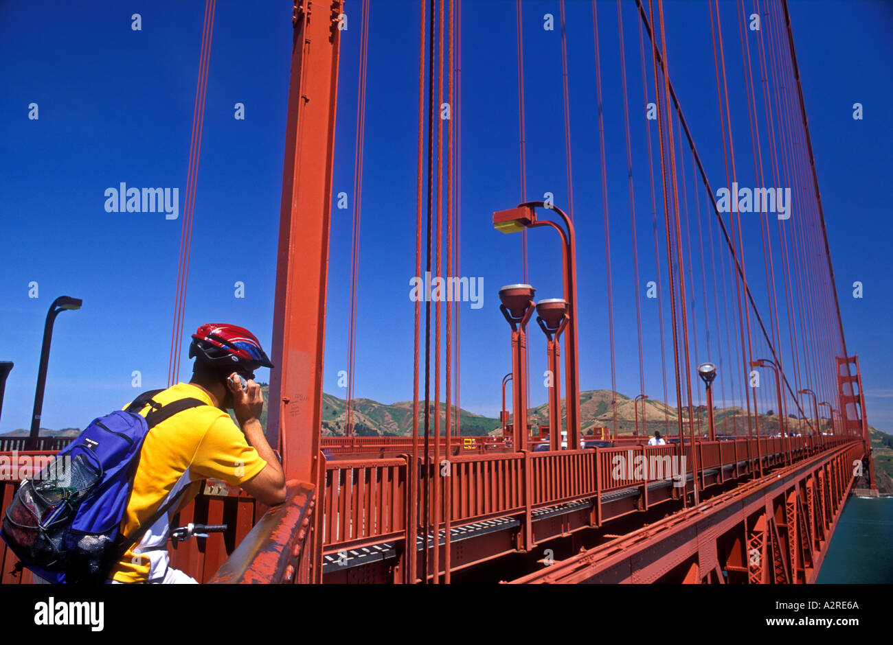 USA California San Francisco cyclist using cell phone on the Golden Gate Bridge Stock Photo