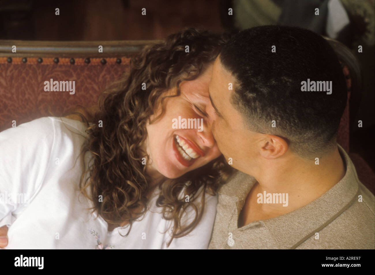 Hispanic man kissing mixed Hispanic woman Stock Photo
