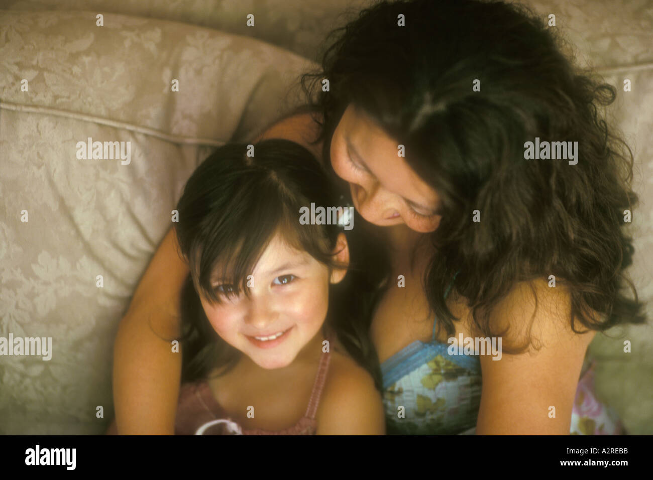 Mixed Asian Caucasian mother hugging 4 year old daughter Stock Photo