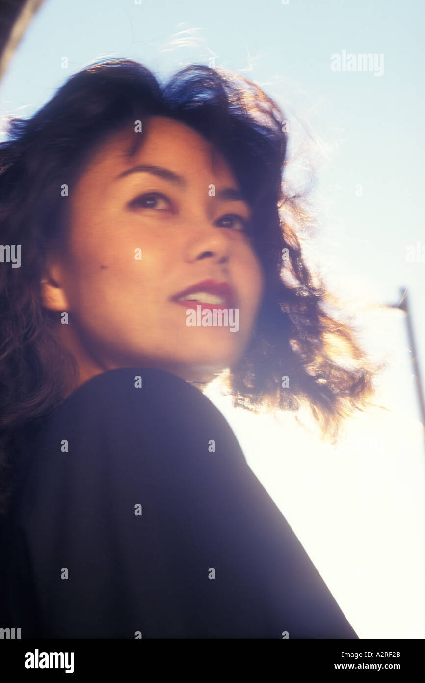 Japanese Okinawan woman in business suit looking over shoulder Stock Photo