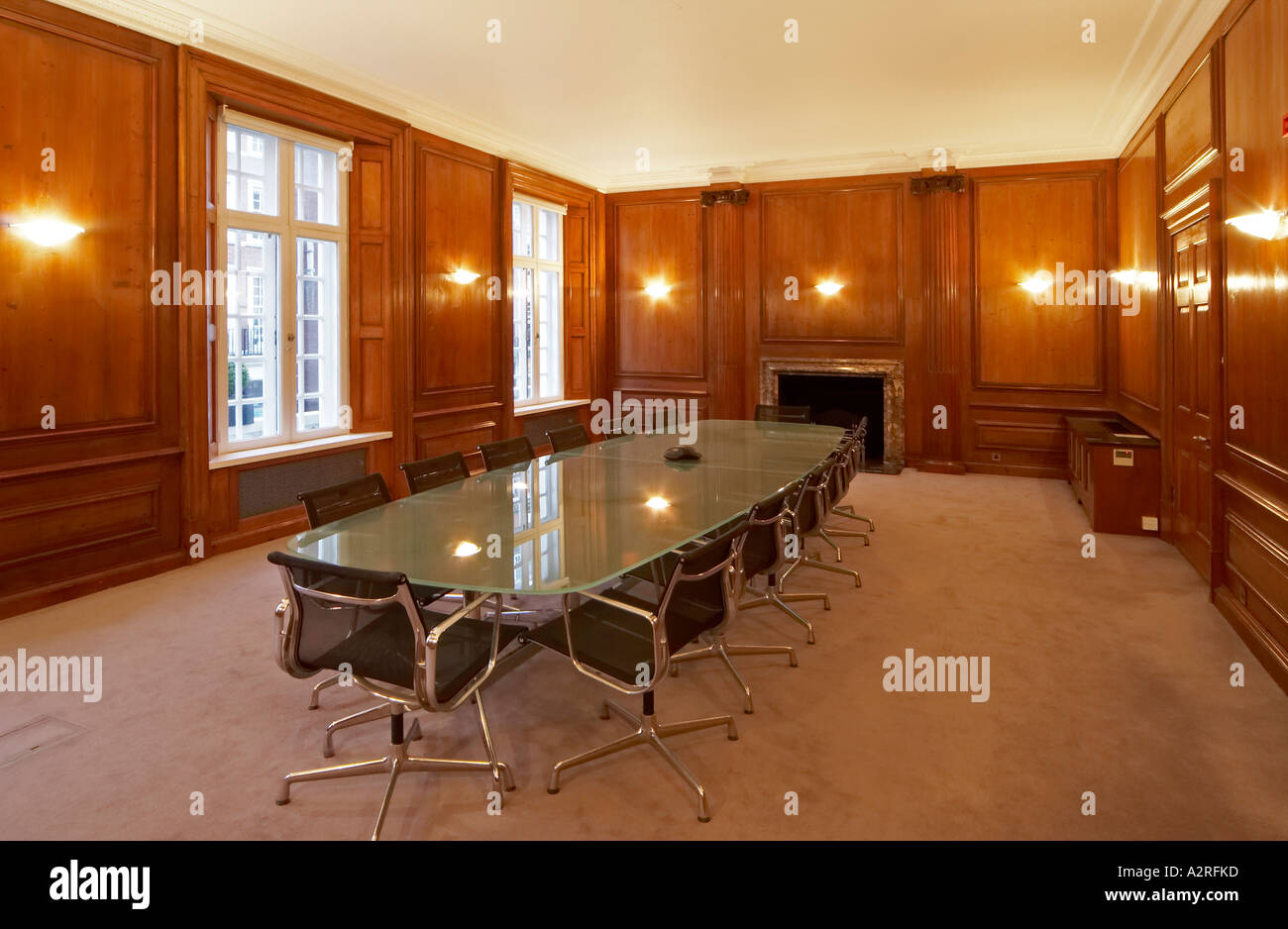 Corporate Business Boardroom meeting room with glass table and oak panelled walls Stock Photo
