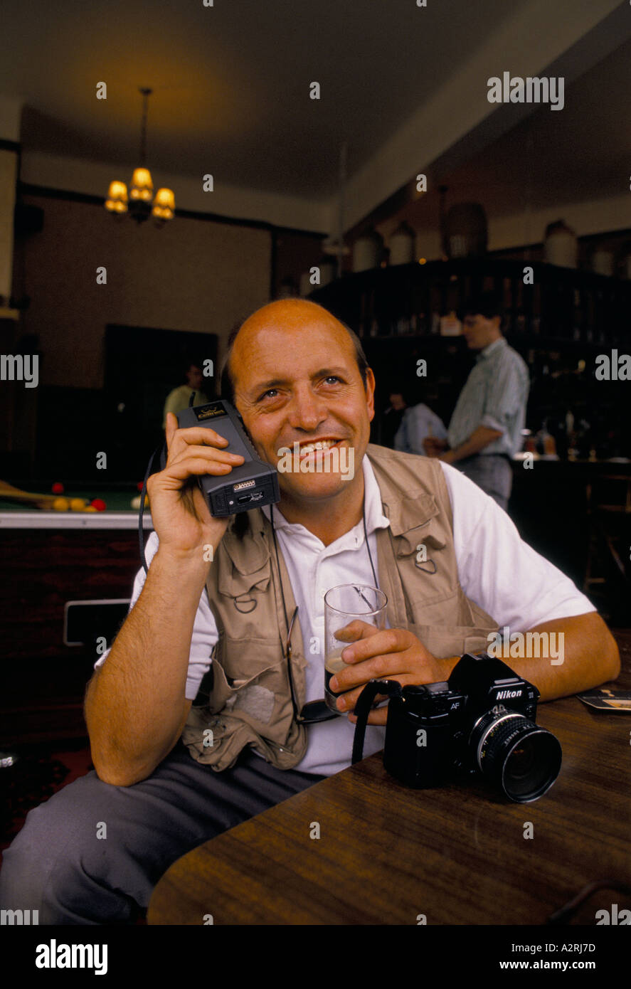 man with old mobile phone in a pub Stock Photo