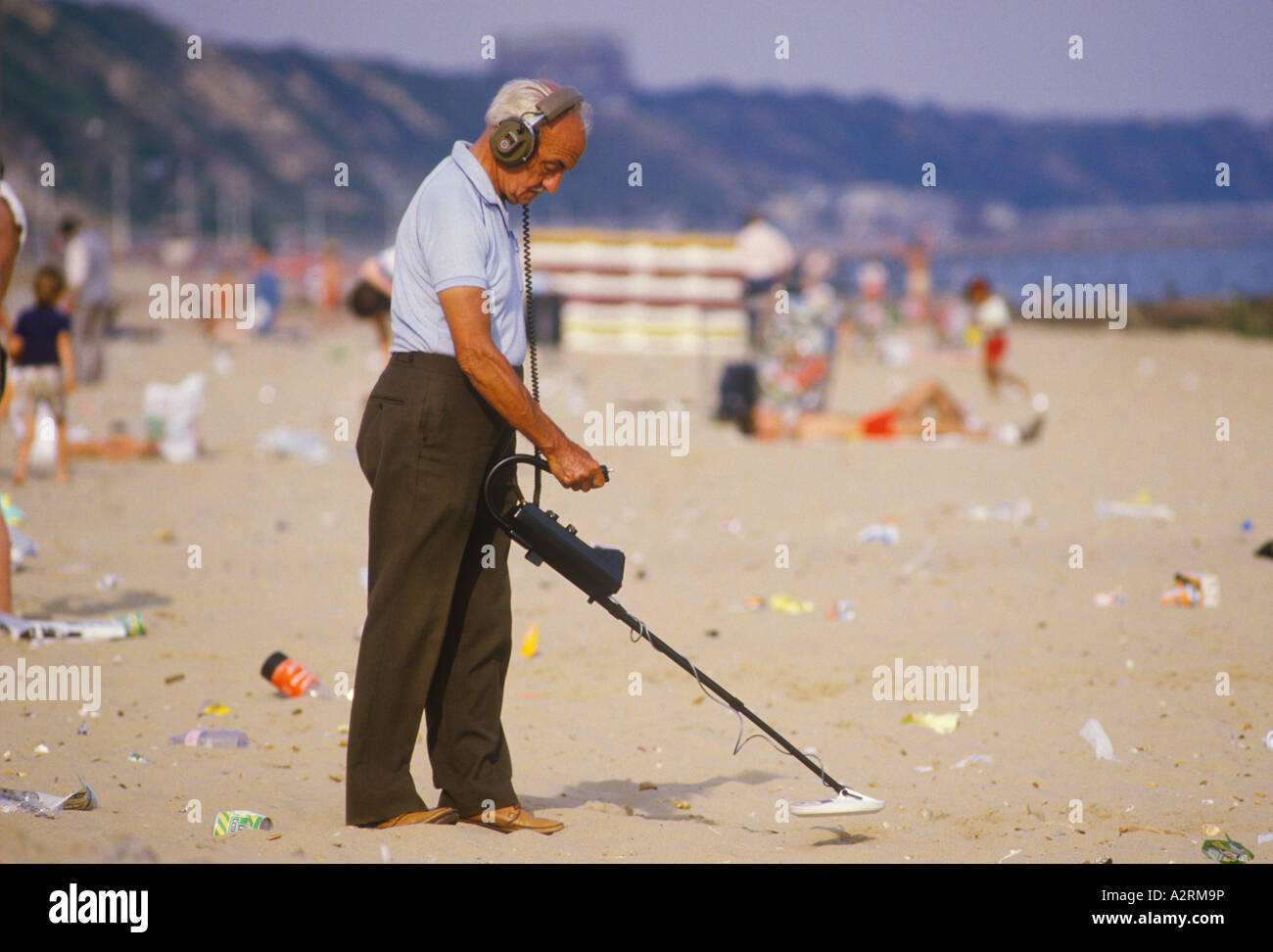 Man using metal detector Eastbourne beach England 1980s, 80s HOMER