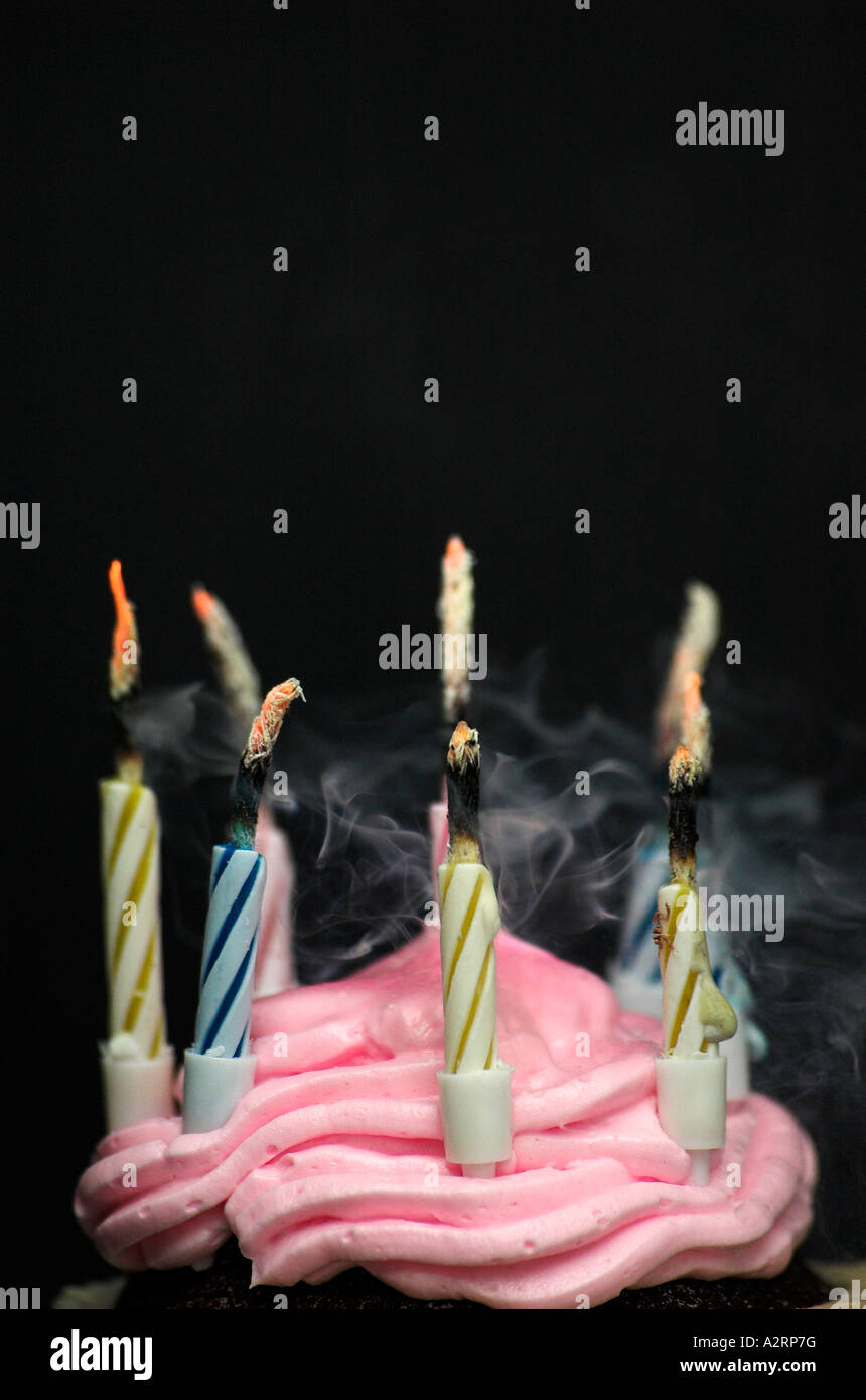 Smoking extinguished candles on birthday cake black background Stock