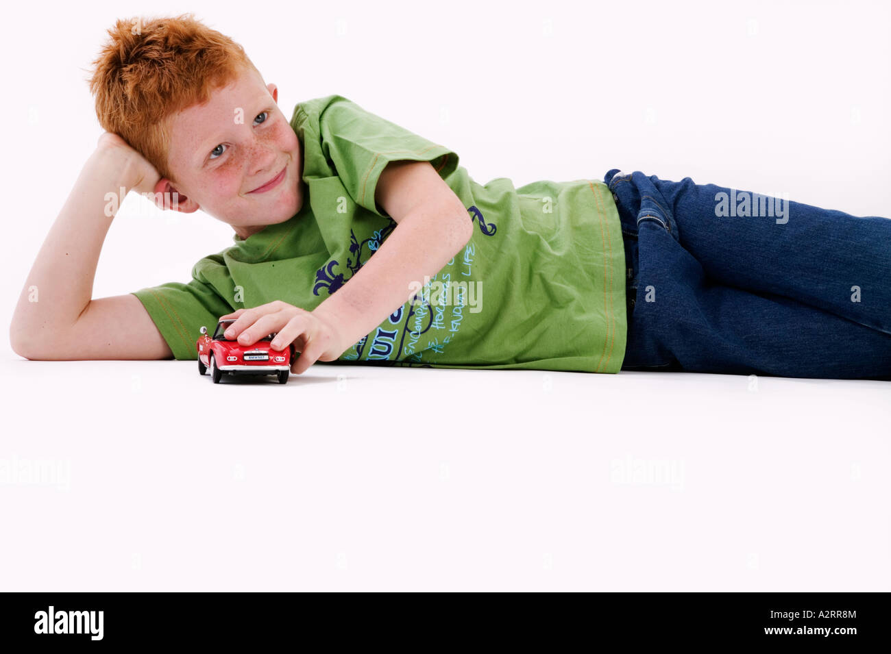 Young boy with red hair and freckles age 7 playing with a toy car Model released Studio shot Stock Photo