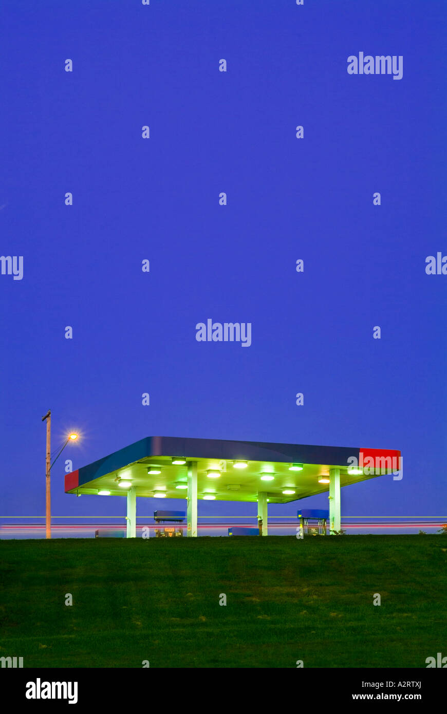 Gasoline Station At Twilight With Bright Lights And Blue Sky Stock Photo