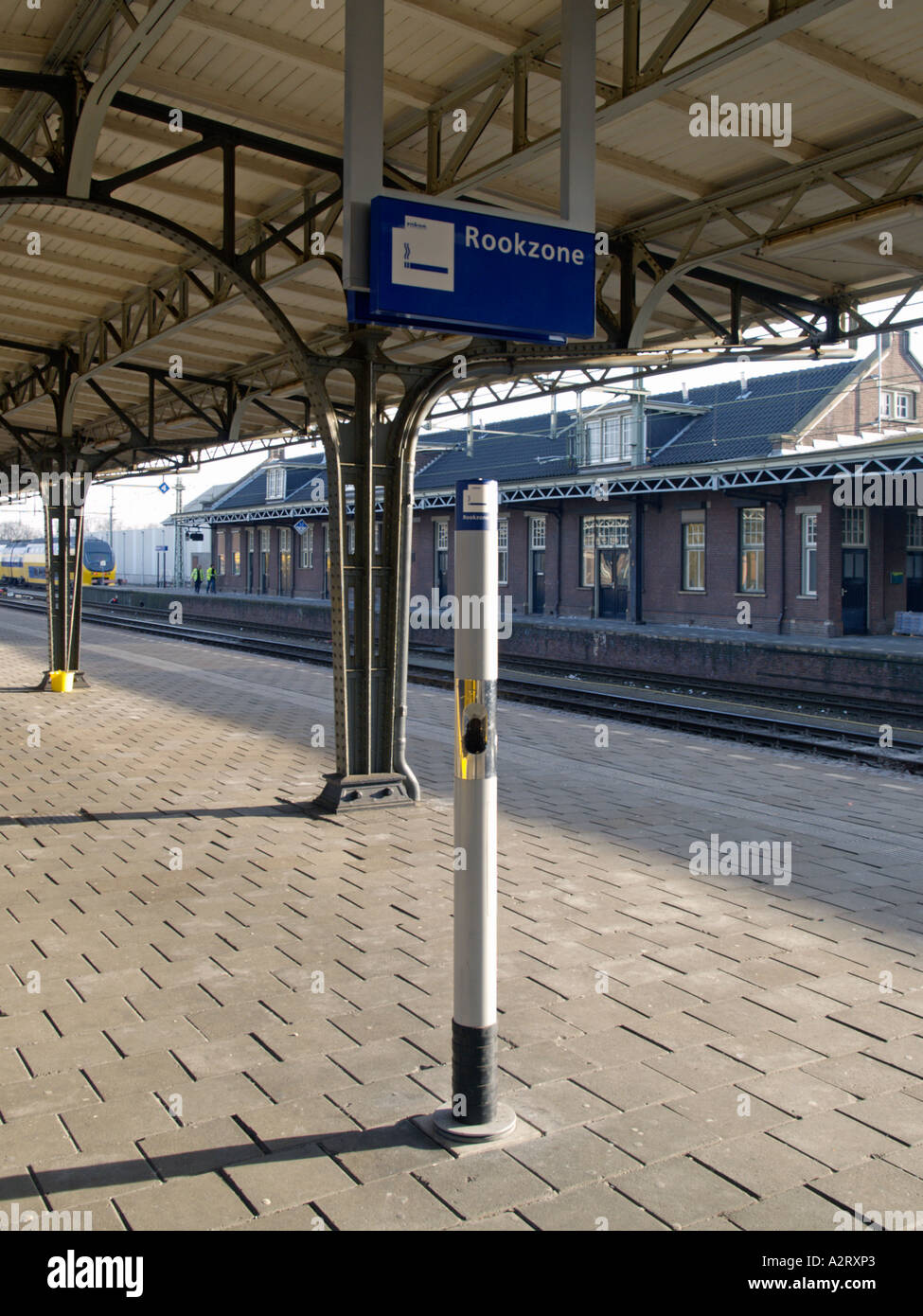 Smoking in train stations in the Netherlands is only allowed near this pole with built in ashtray called the pafpaal Stock Photo