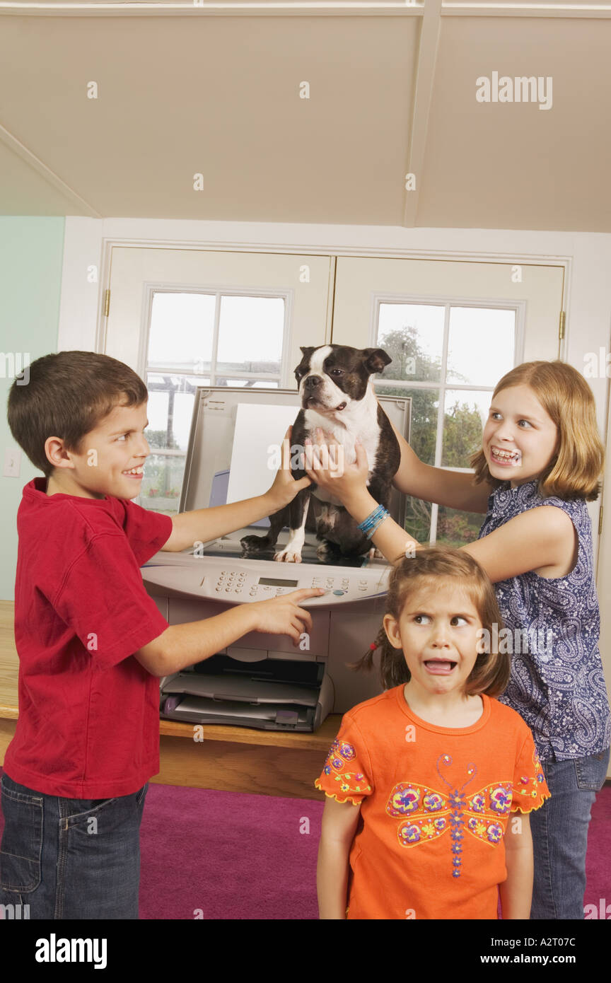 Three kids faxing a dog Stock Photo