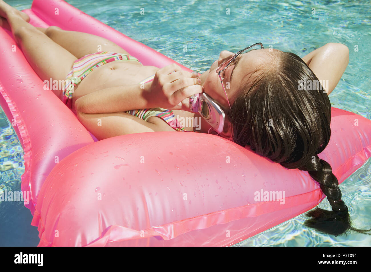 Girl talking on a mobile phone in a pool Stock Photo