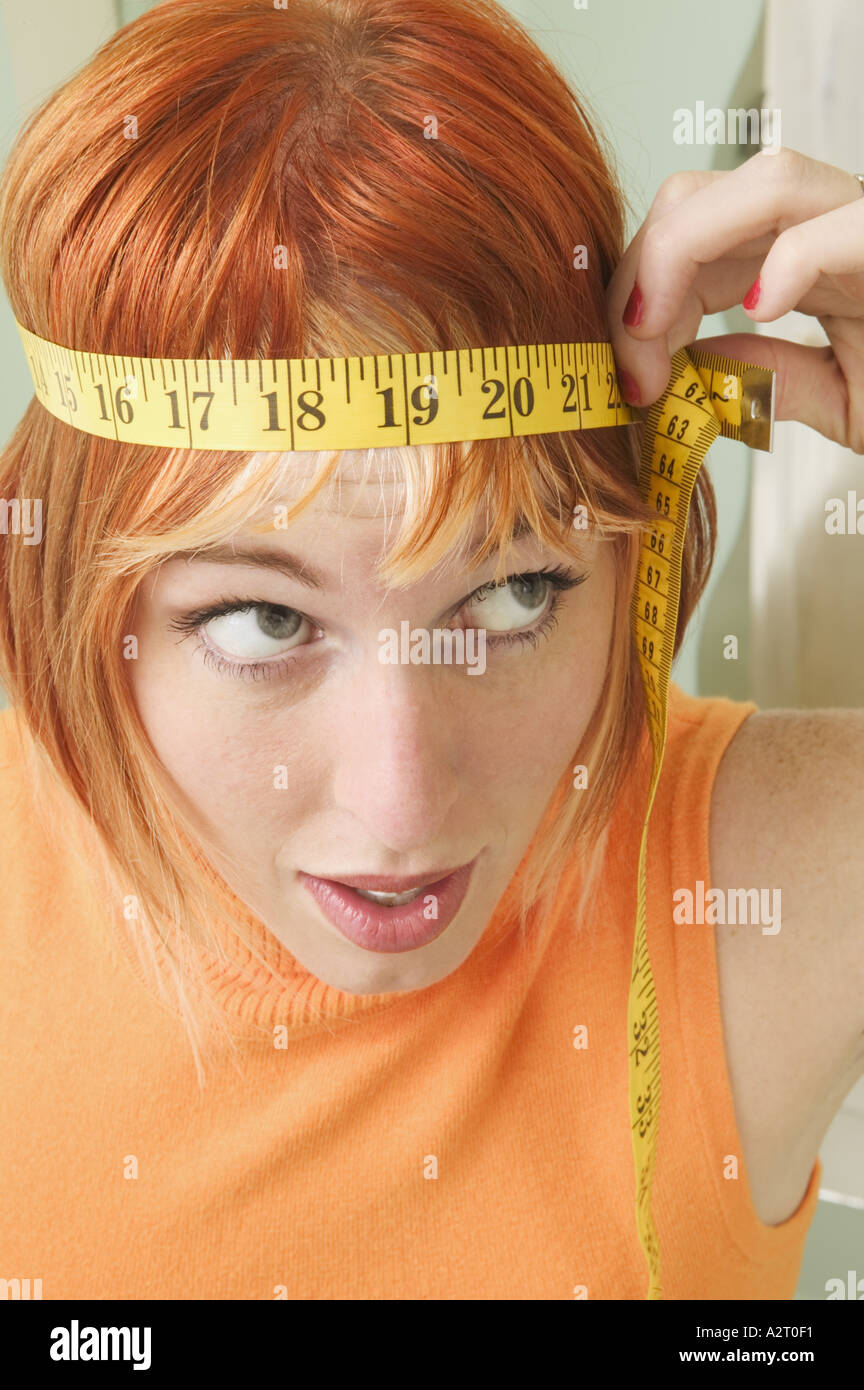 Woman with measuring tape around her head Stock Photo