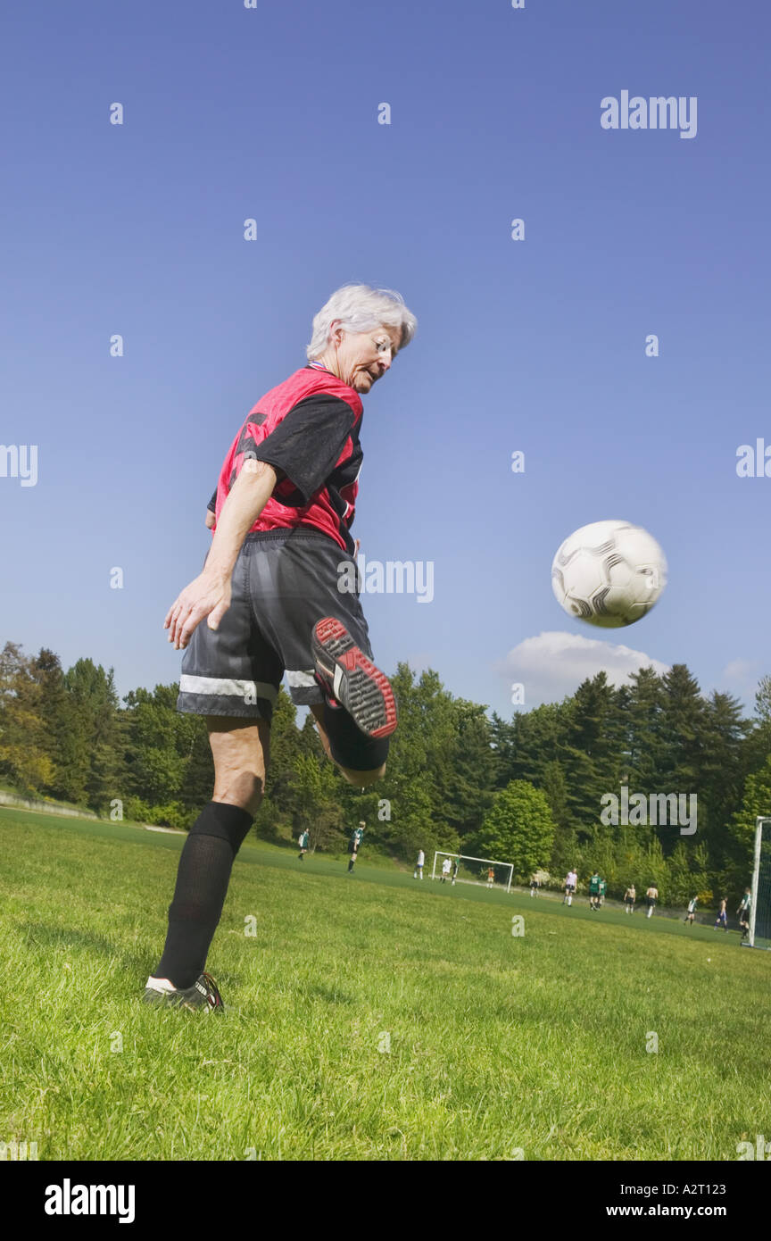 An older woman playing soccer Stock Photo