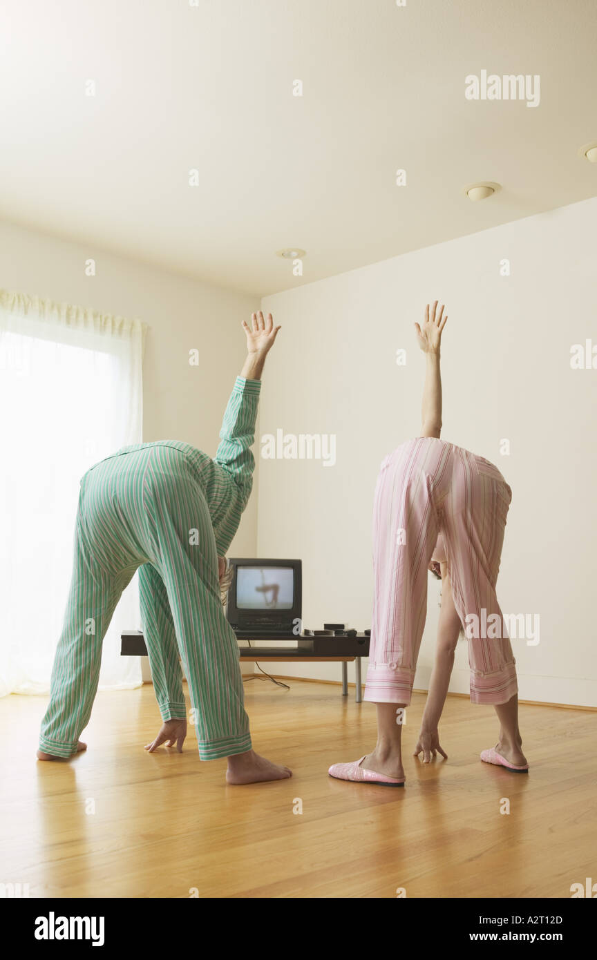 Middle aged couple exercising to a TV program Stock Photo