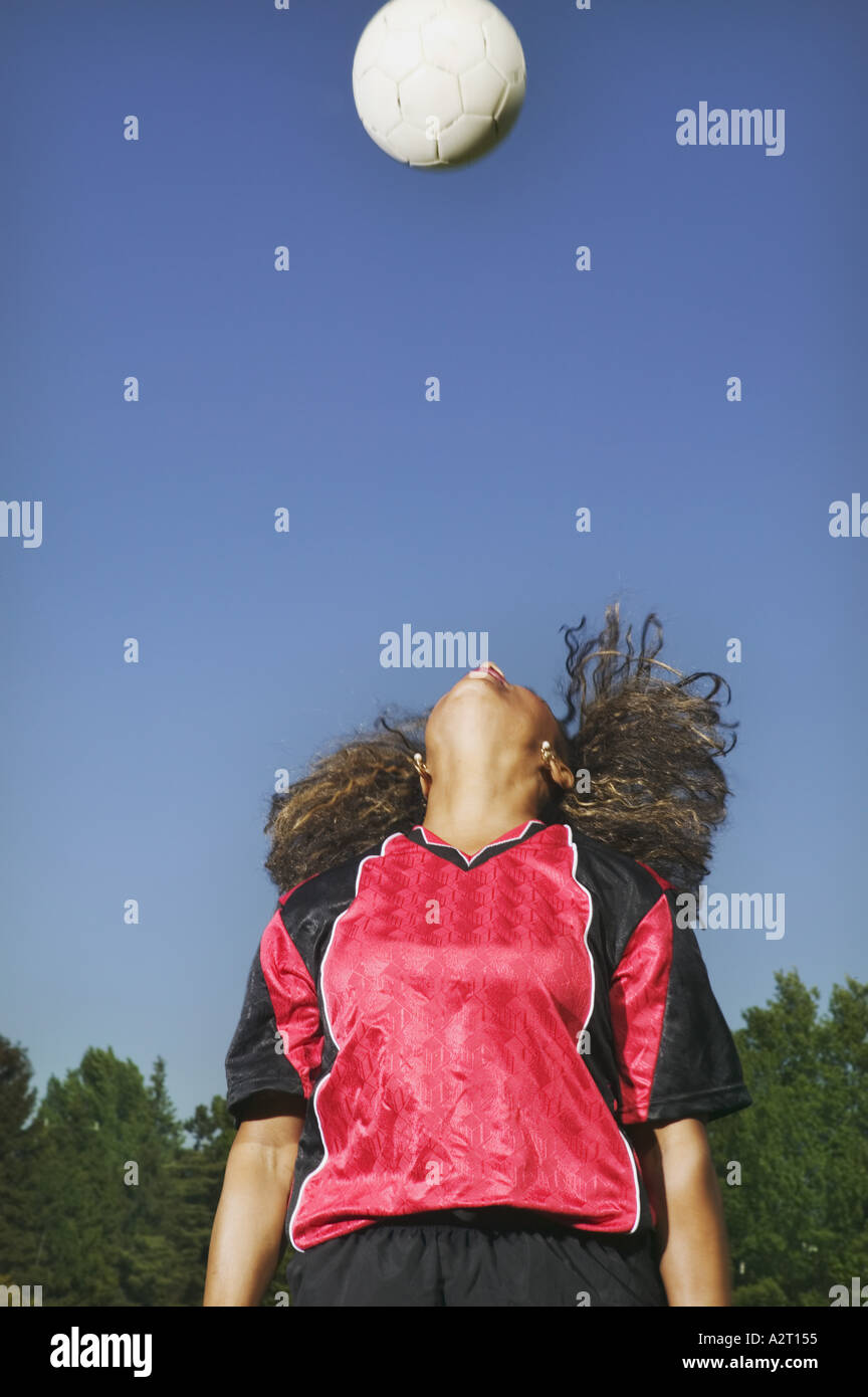 A young woman heading a soccer ball Stock Photo