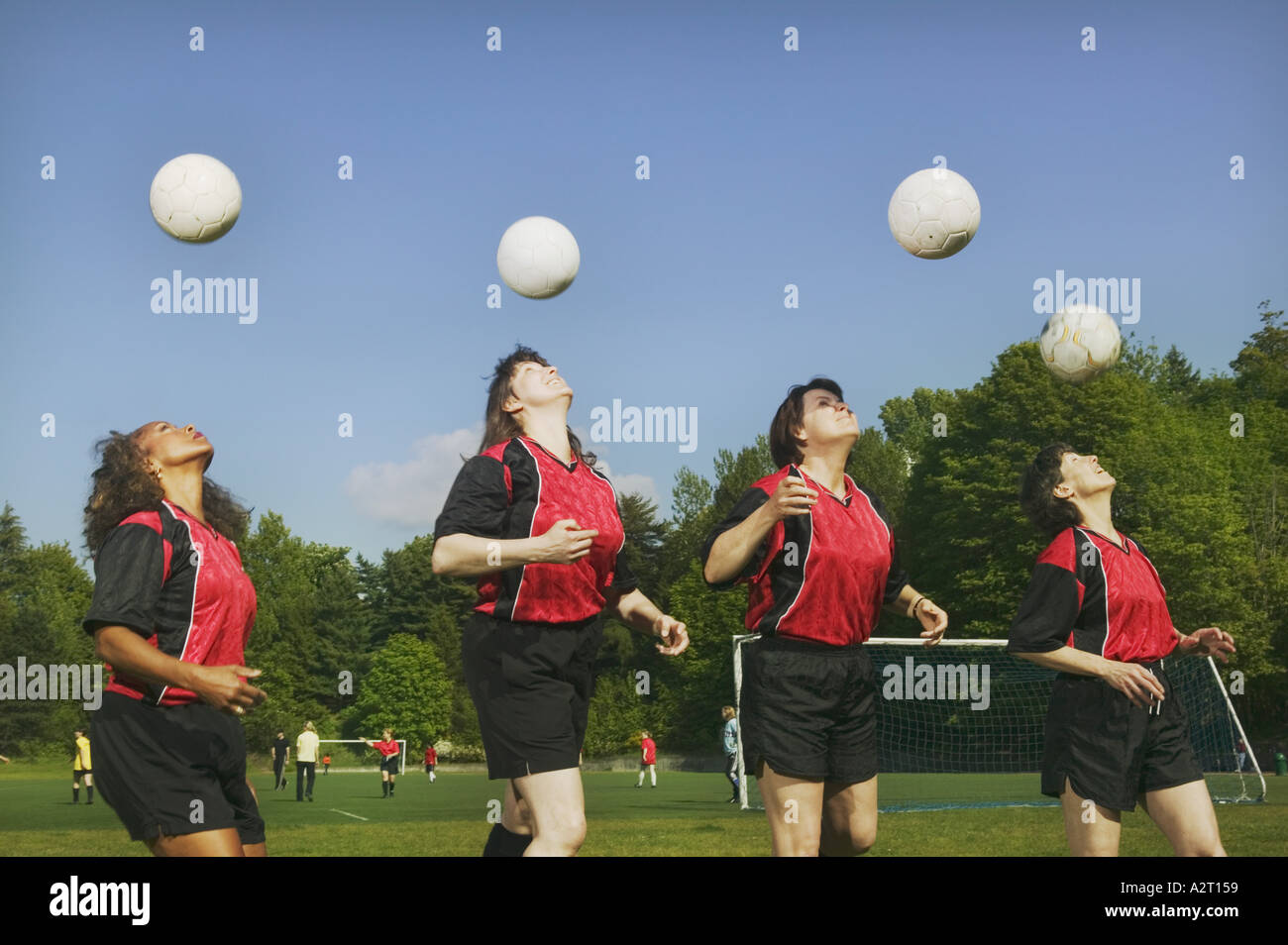 Four young female soccer players heading balls Stock Photo
