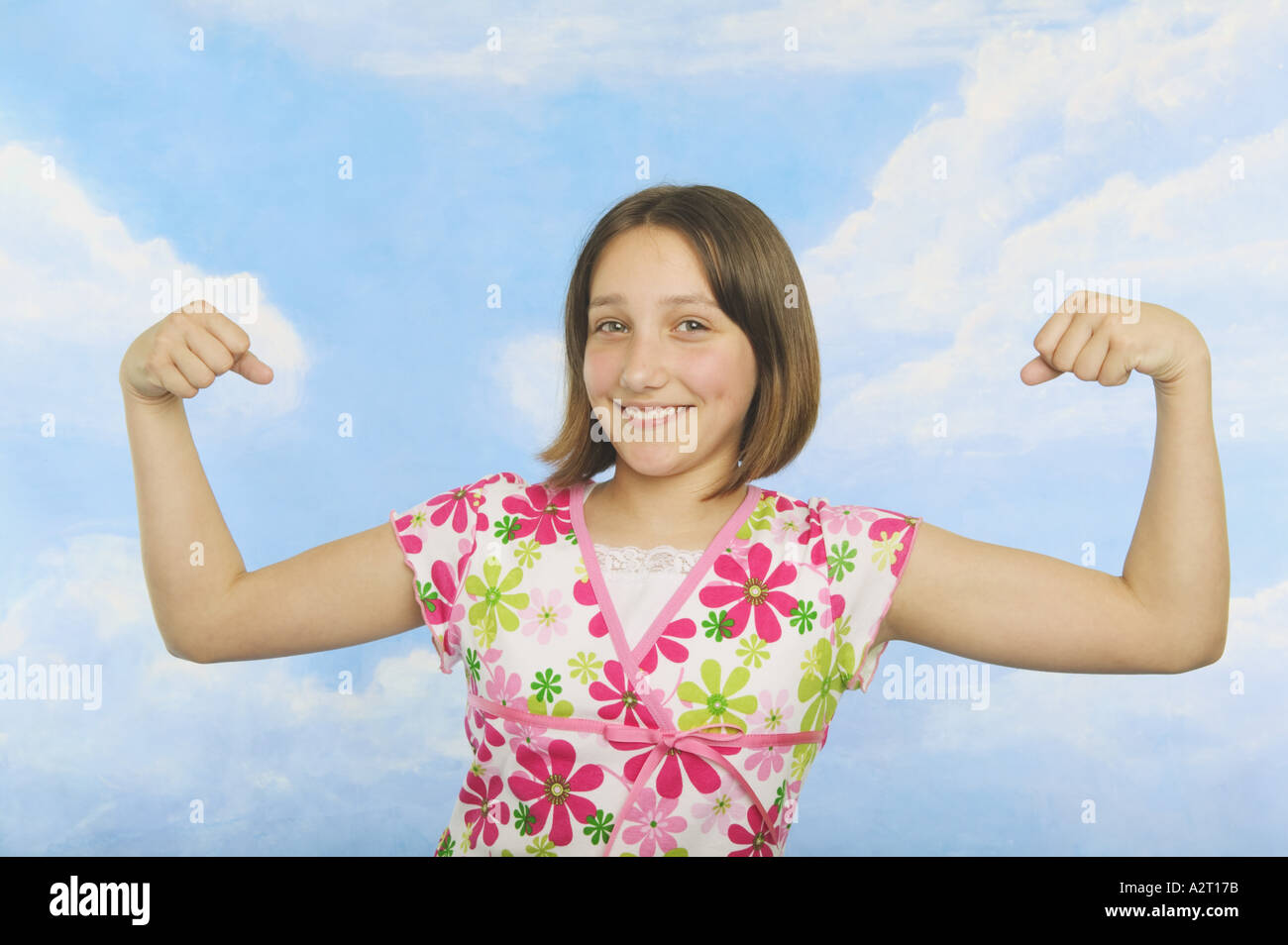 A teenaged girl flexing her muscles Stock Photo