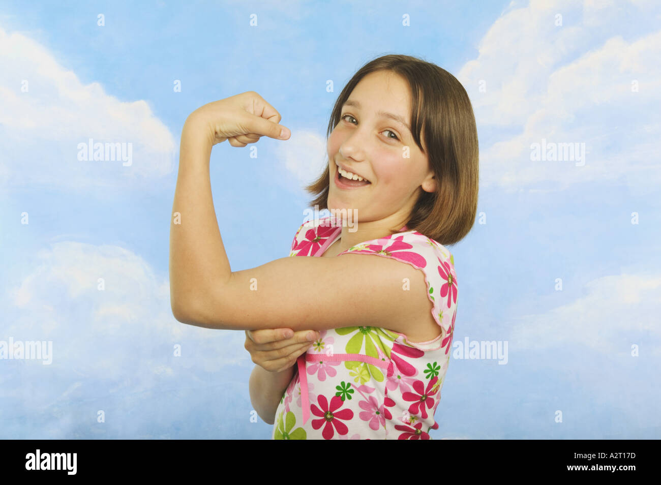 A teenaged girl flexing her muscles Stock Photo