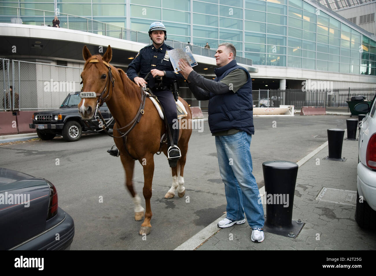 Police Officer gives directions to tourist near Government office South Ferry New York City. USA. Stock Photo