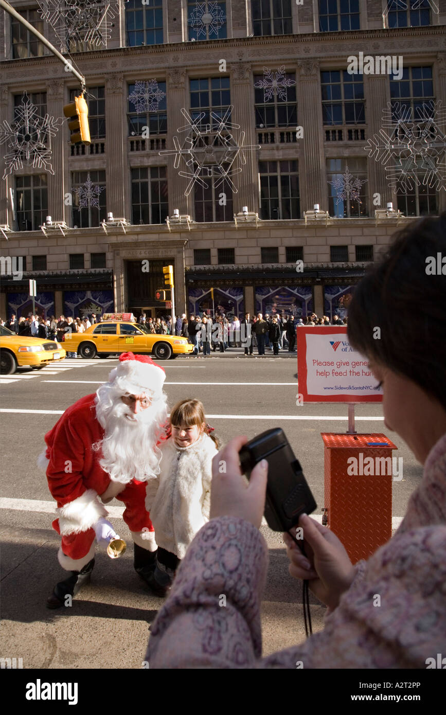 Girl meets Santa Claus near Rockefeller Centre and Saks Fifth Avenue New York City USA Stock Photo