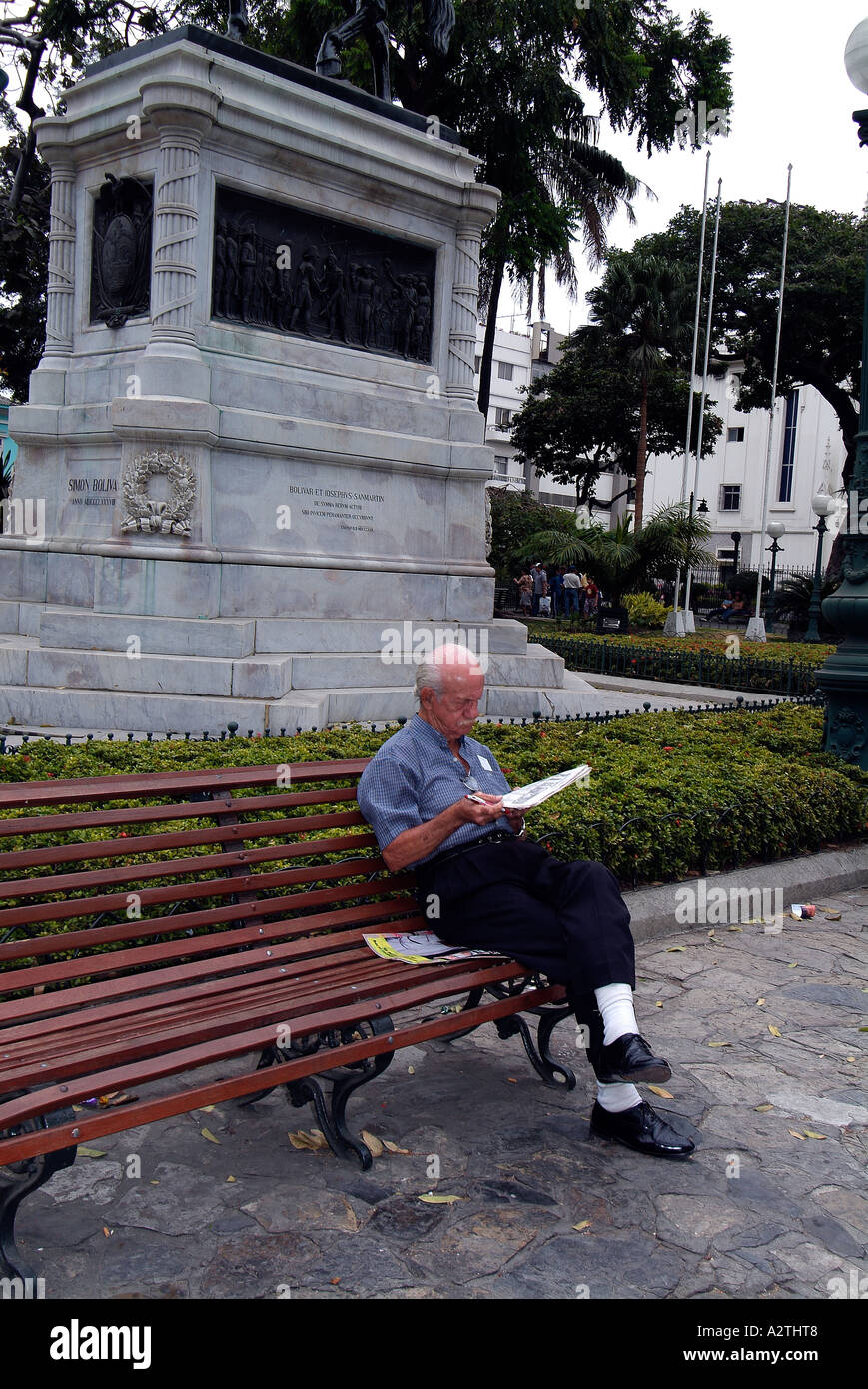 Man sitting on a bench and reading a newspaper Stock Photo - Alamy