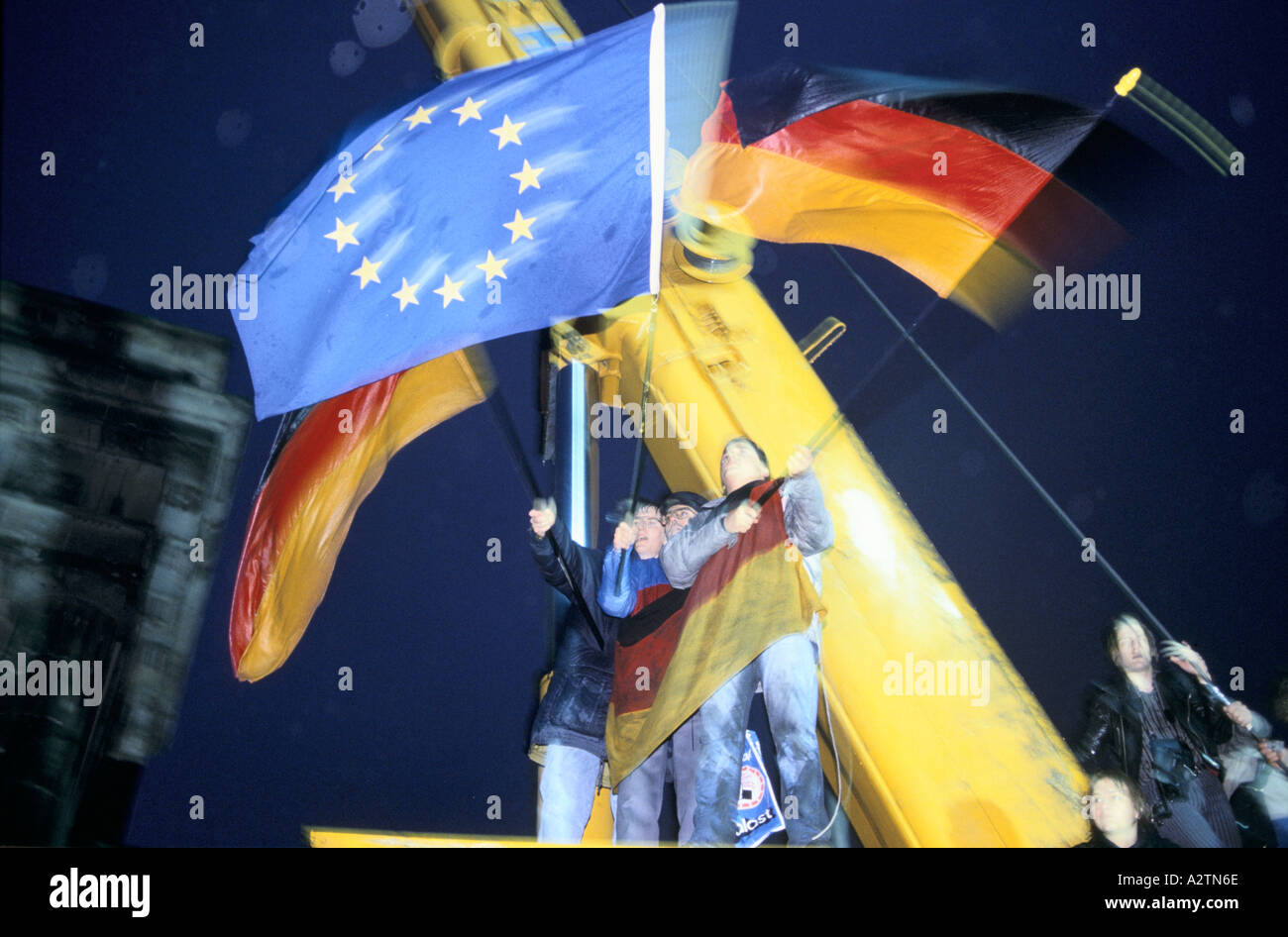 people waving the german and european flags in celebration of the brandenburg gate being opened 1989 Stock Photo