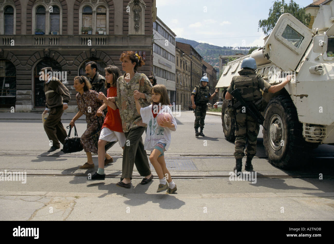 sarajevo june 1995 people walk off the un tank after being shielded crossing a sniper susceptible road Stock Photo