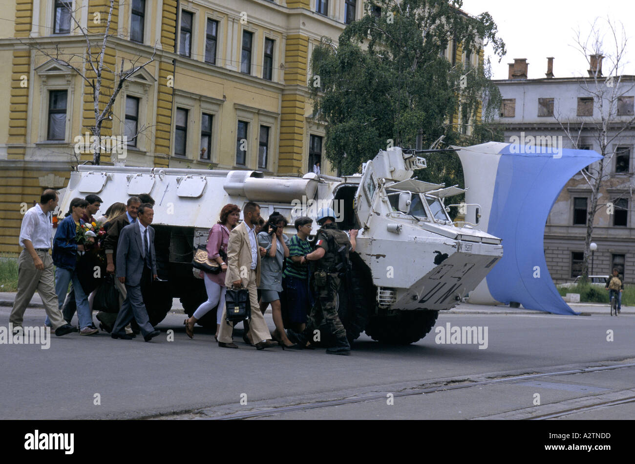 sarajevo june 1995 un tank armed soldiers shielding people as they cross sniper susceptible roads Stock Photo