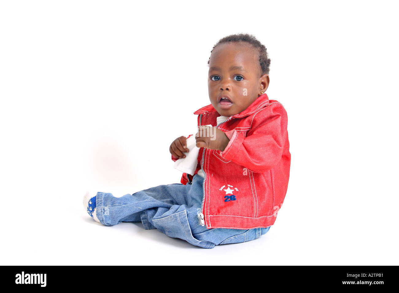 Black baby girl with red denim jacket and jeans holding a piece of cloth Stock Photo Alamy