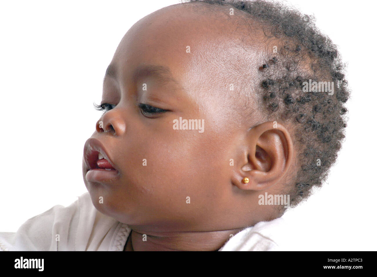 3 4 shot of black baby girl throwing her head back and looking down with tongue sticking out between her teeth Stock Photo