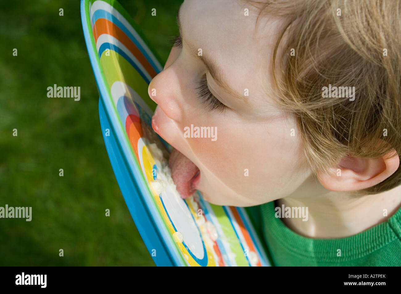 Boy licking food off plate Stock Photo Alamy