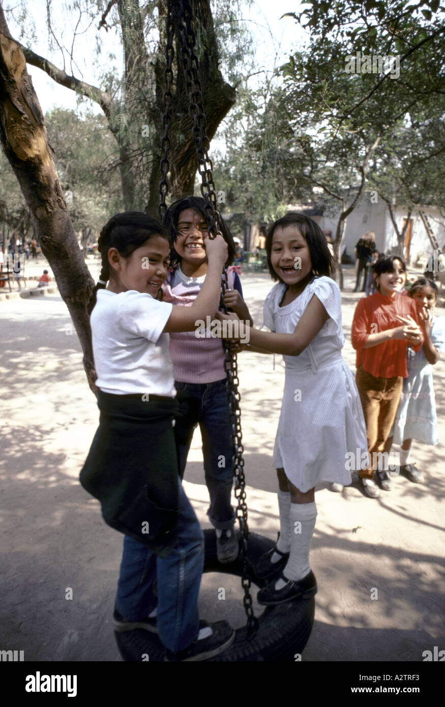 three girls standing on a swing mexico Stock Photo