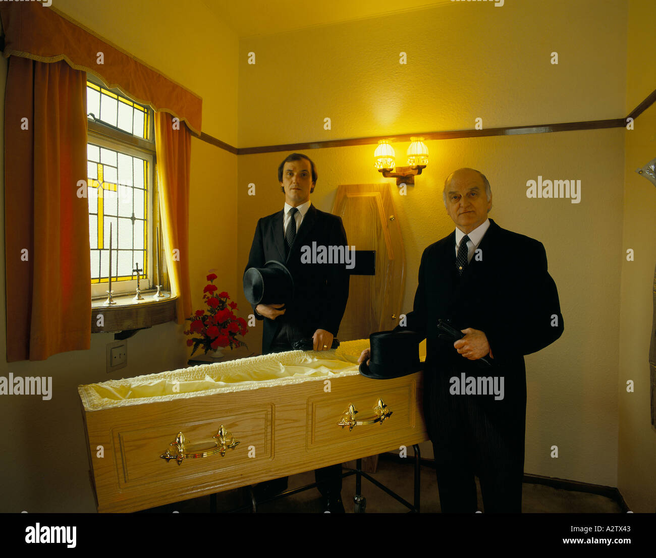 funeral parlour chief mourners next to an empty coffin Stock Photo Alamy