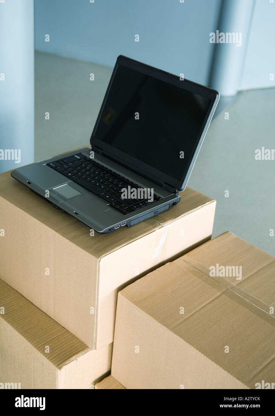 Open laptop on stack of cardboard boxes Stock Photo Alamy