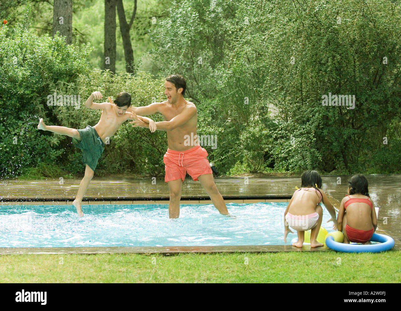 Father throwing son in swimming pool Stock Photo Alamy