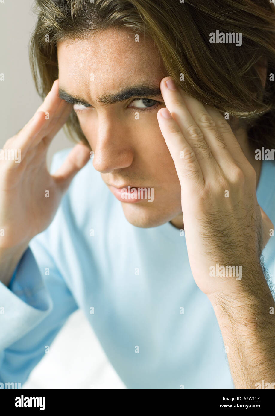 Young man holding temples Stock Photo