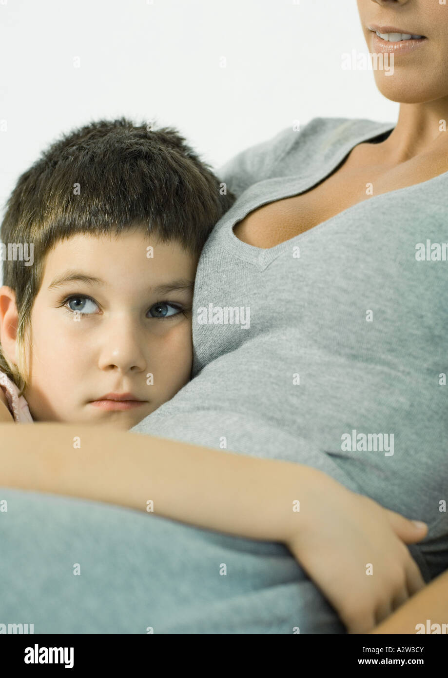 Child leaning against mother, hand around her waist Stock Photo Alamy