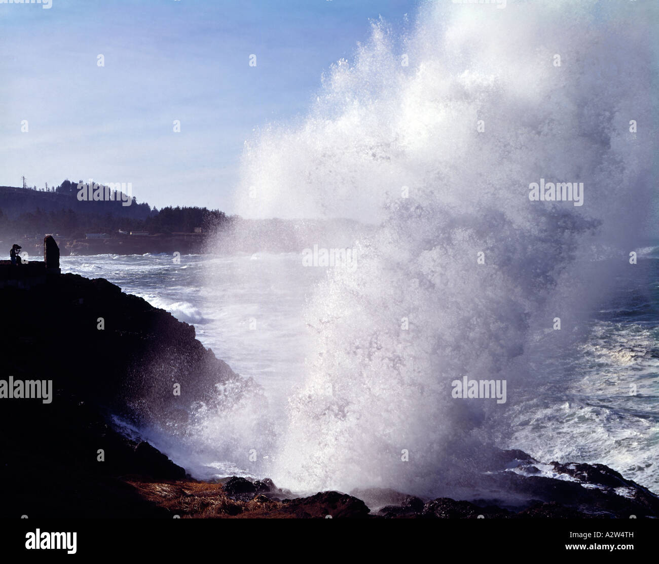 Big waves crash into shoreline rock formations at Depoe Bay in Oregon creating a spray of water and mist Stock Photo
