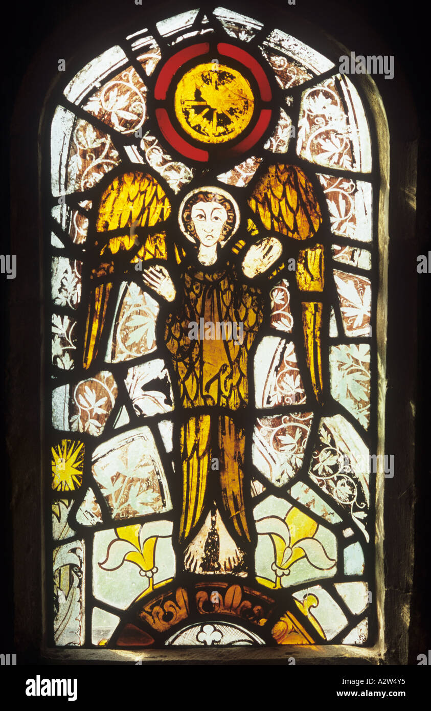 Medieval stained glass church window with a quirky angel holding Stock