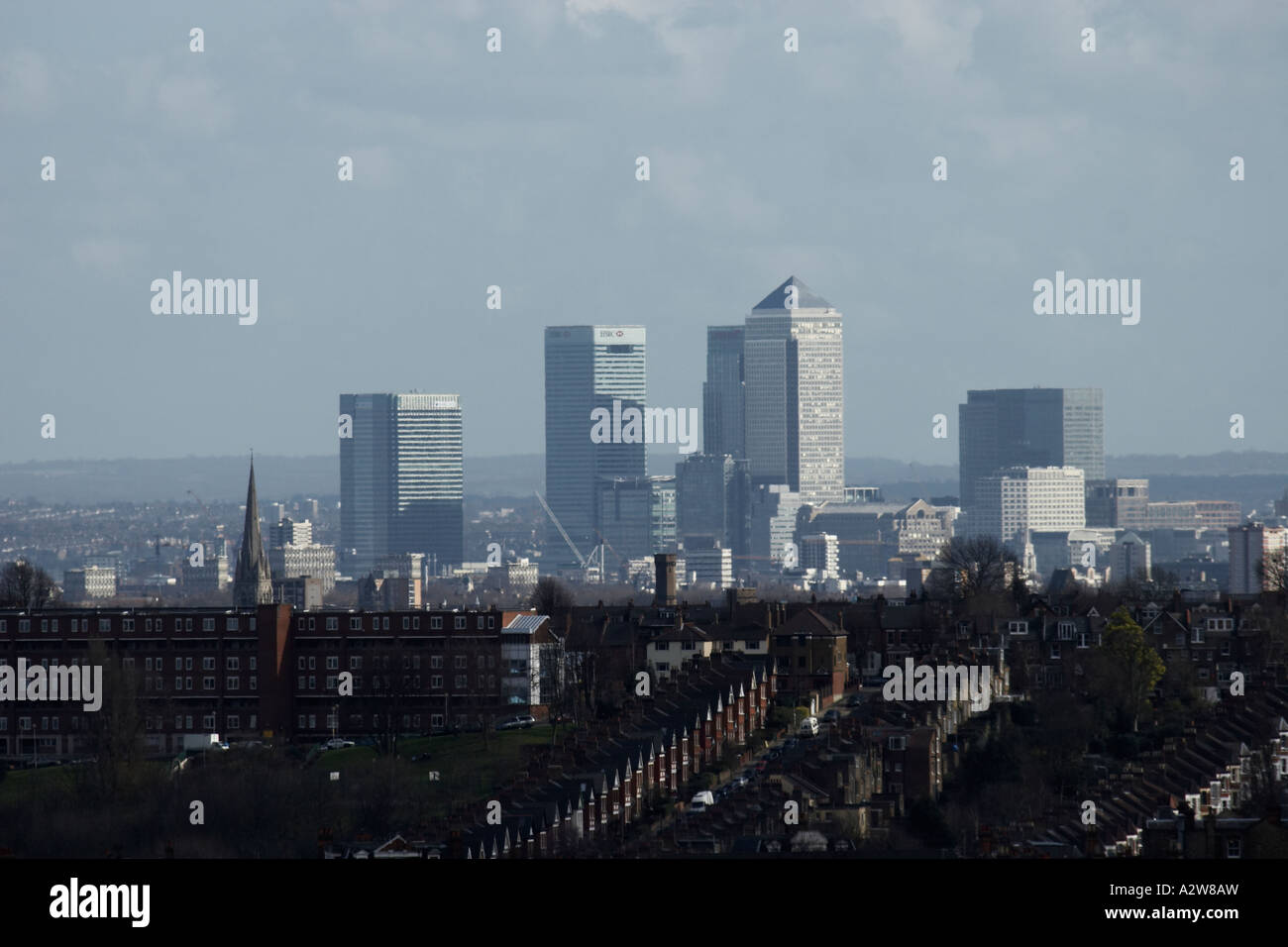 Distant view of tall buildings  skyscrapers in Canary Wharf across suburban rooftops of London from Alexandra Palace London N10 Stock Photo