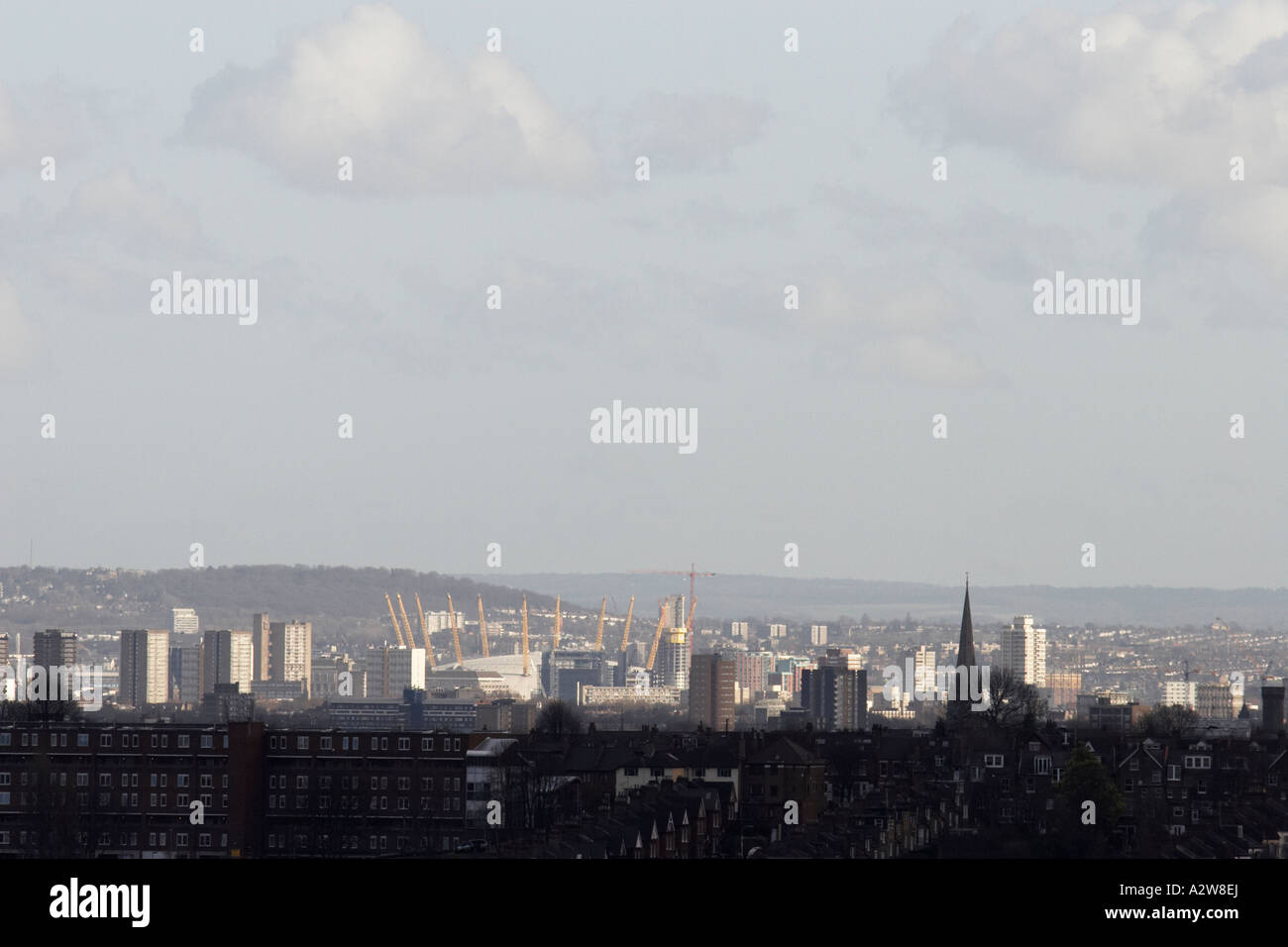 Distant evening view of tall buildings and Millenium Dome Greenwich across suburban rooftops of London from Alexandra Palace Lon Stock Photo