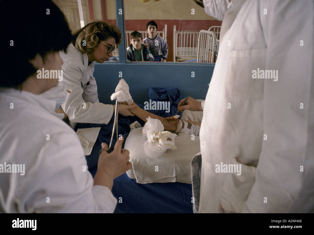 staff tending complicated shrapnel wounds on child s leg scene from
