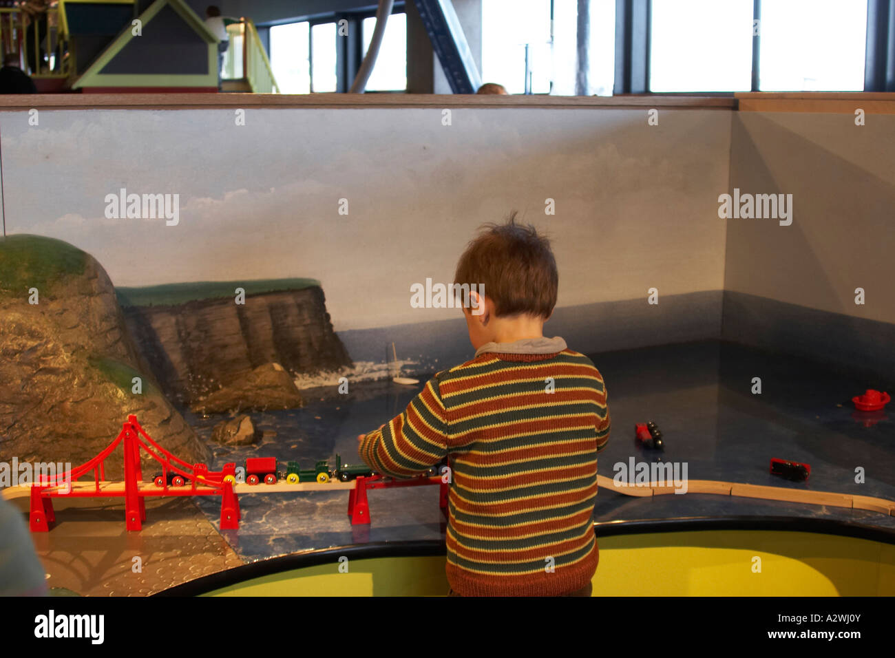 Young boy child playing with model railway train toy in Odyssey W5