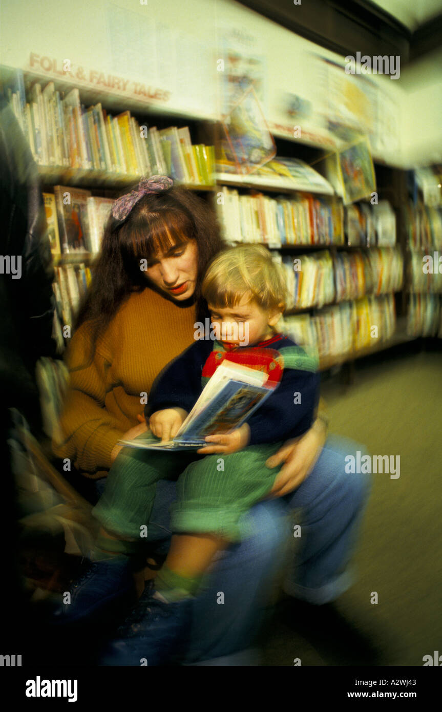 woman helping child to read book toy library muswell hill Stock Photo