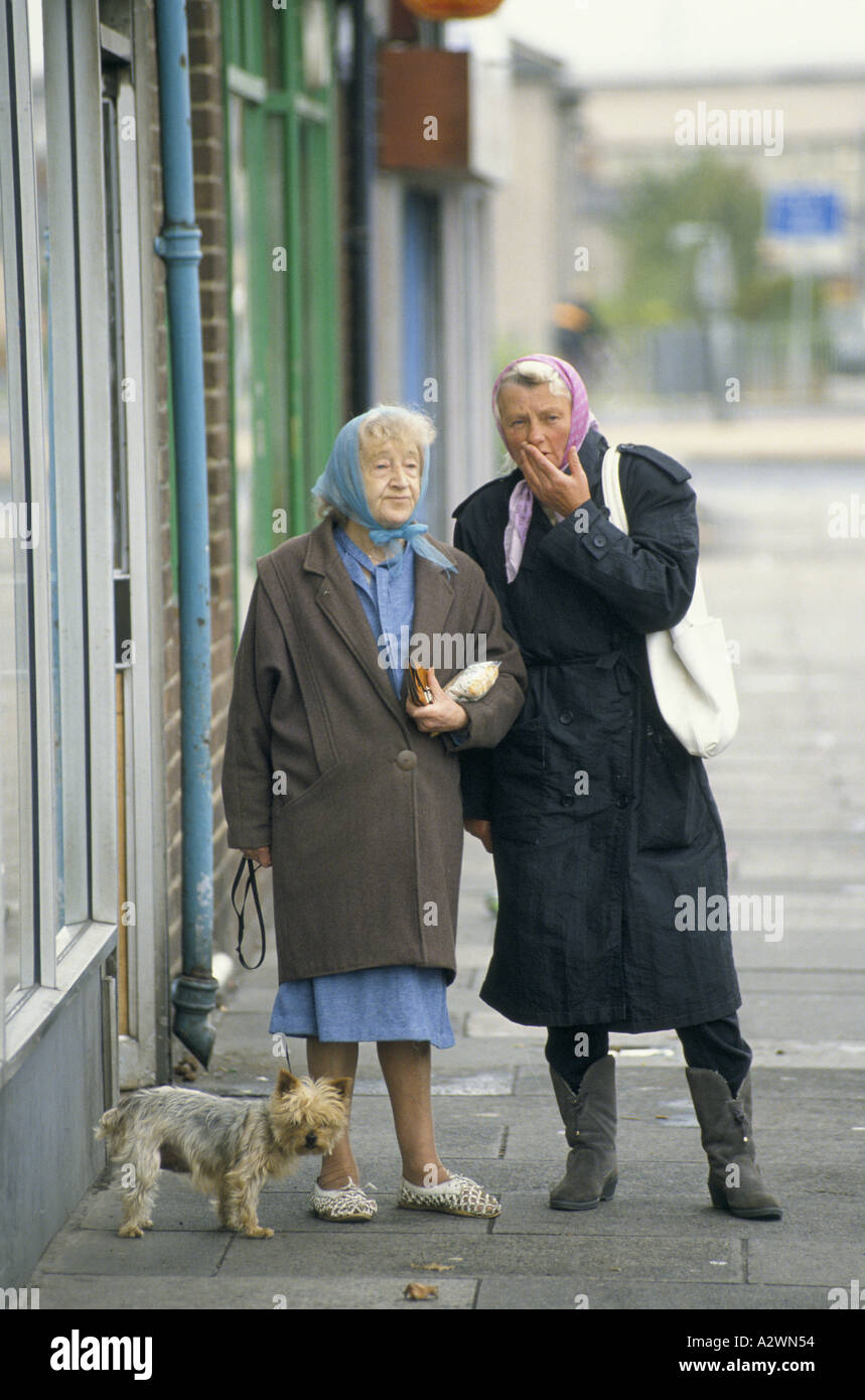 Two elderly women with Yorkshire terrier chatting on the street of Grangetown, South Wales Stock Photo