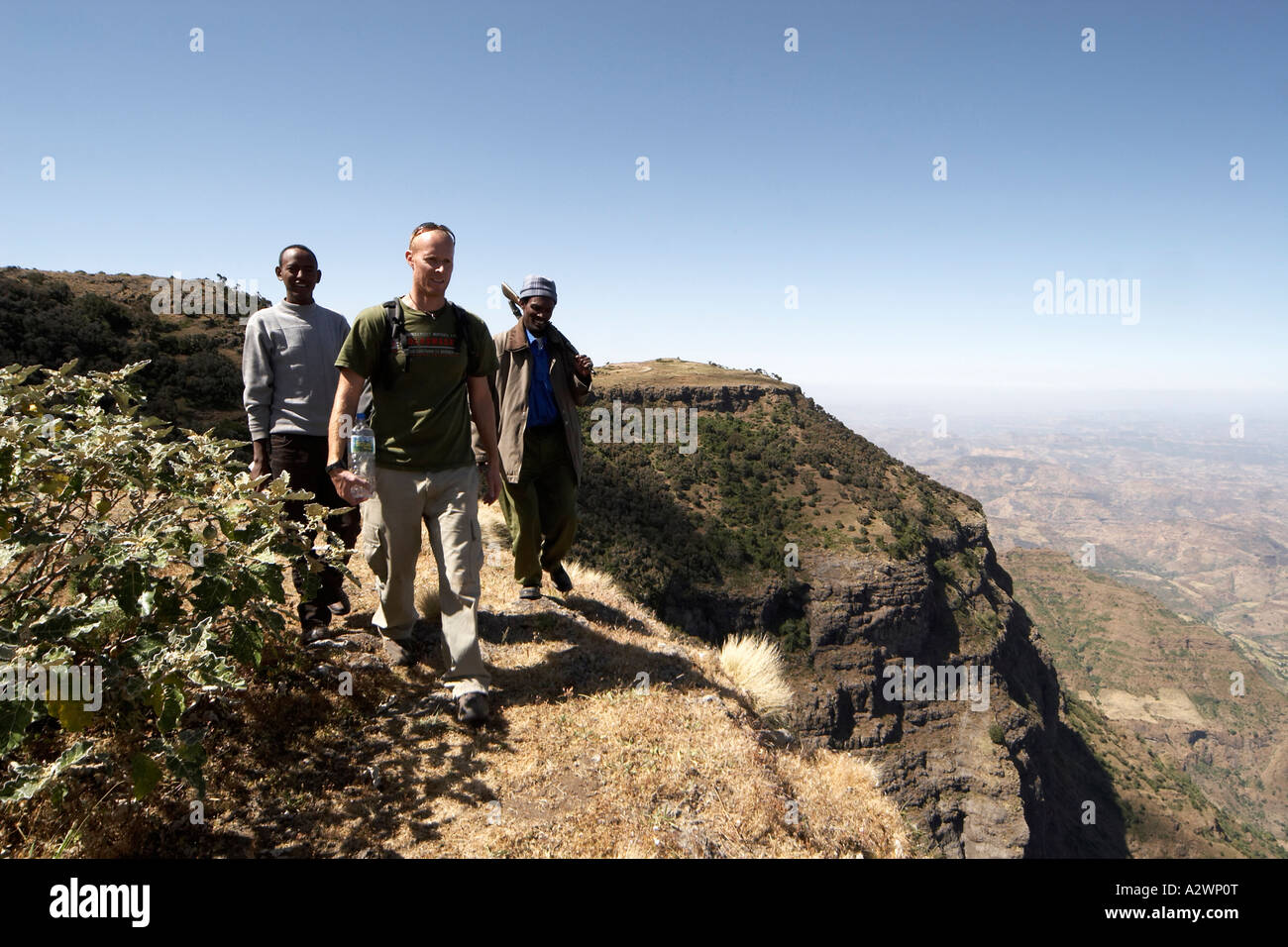People walking along escarpment cliffs in Simien Mountains National ...