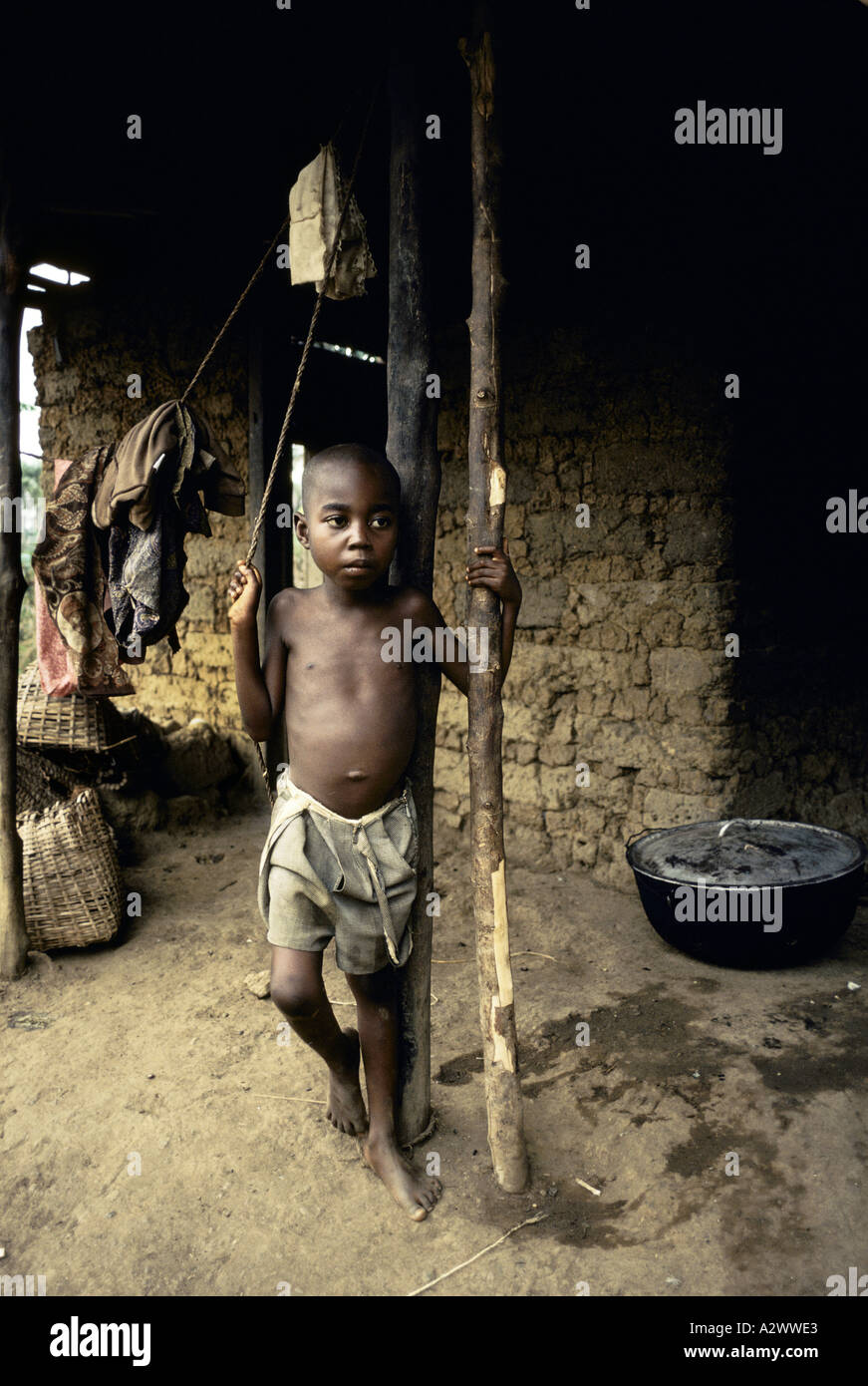 A boy stands outside his house in Njaluahan village, Sierra Leone, Africa, Stock Photo