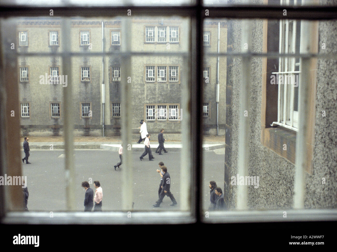 Prisoners in the exercise yard at Saughton Prison, seen through a window with bars, Scotland Stock Photo