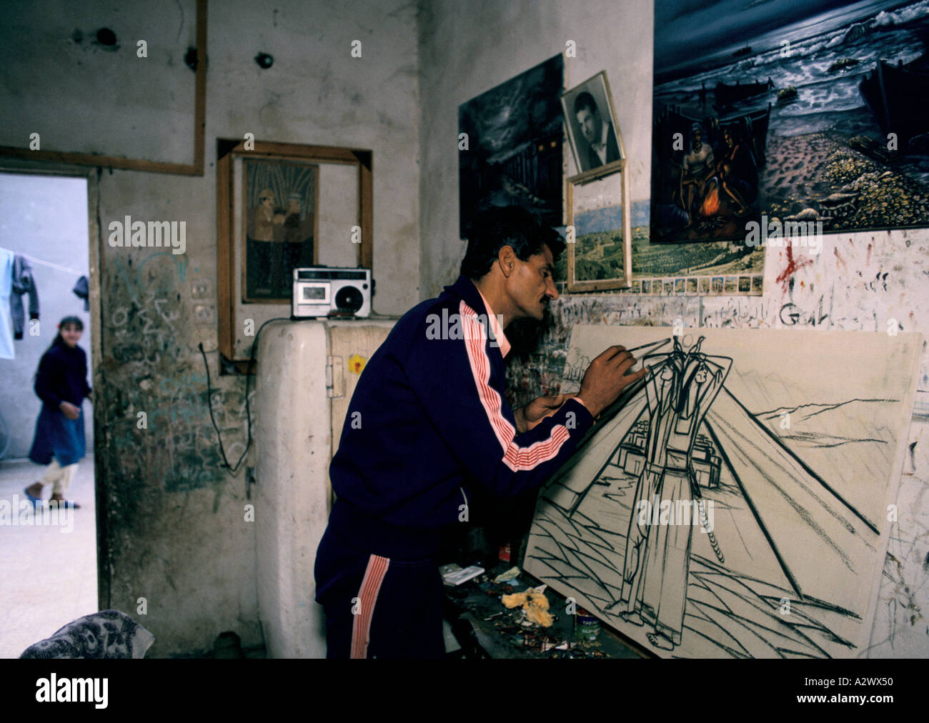 The artist Fathy Chapin painting while his daughter plays in the yard