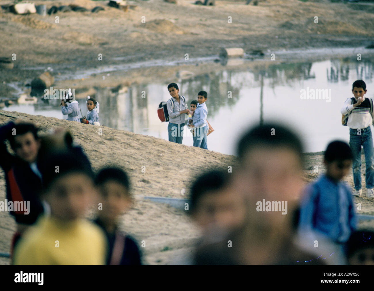 Children playing by the banks of an open    cesspit. Jabalya camp, Gaza, Israeli Occupied      Territories Stock Photo