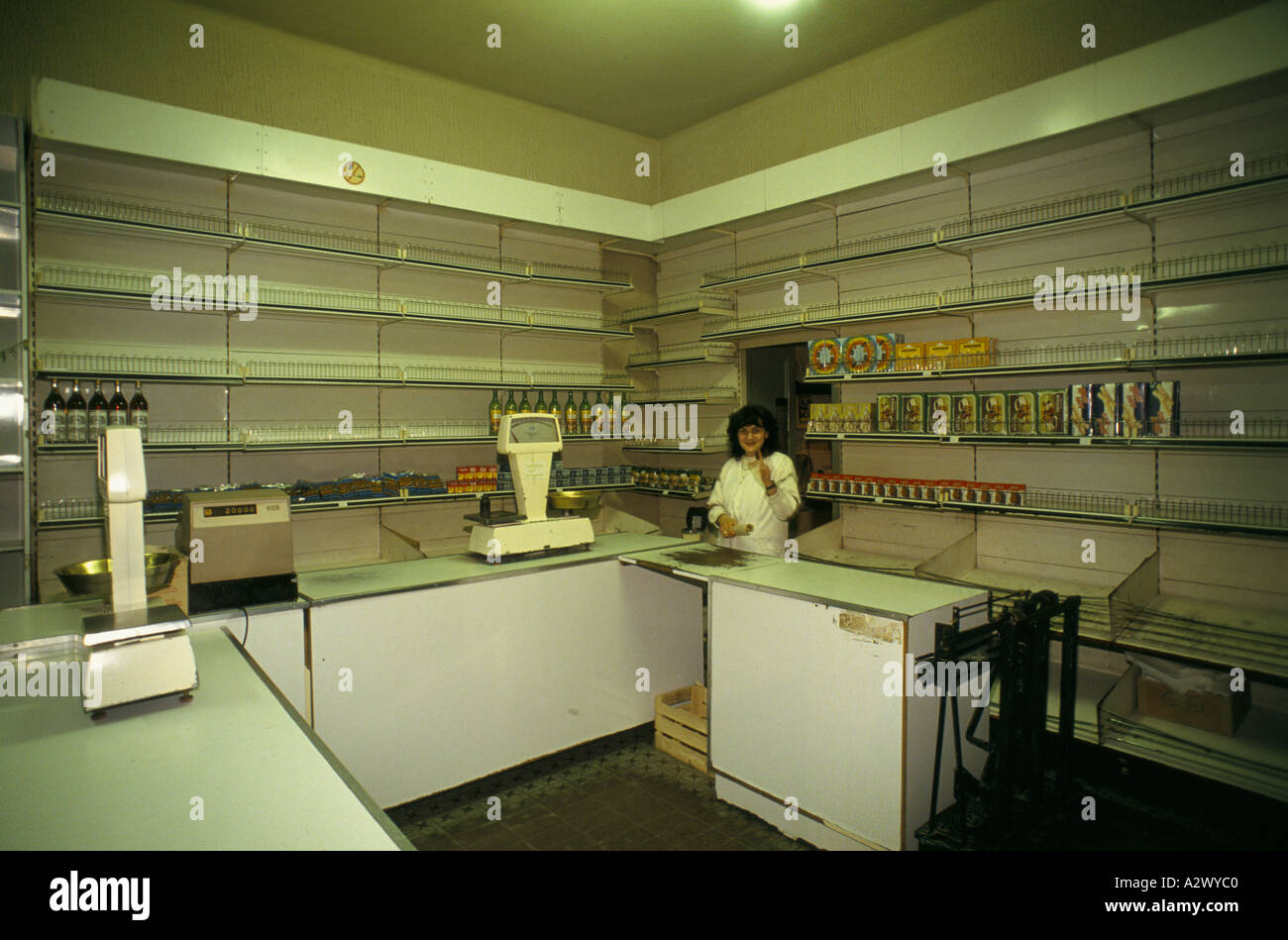 belgrade-under-sanctions-a-shop-assistant-in-shop-with-empty-shelves-A2WYC0.jpg